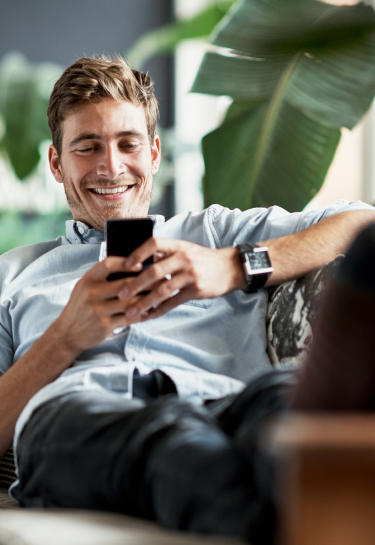 man using mobile phone on couch