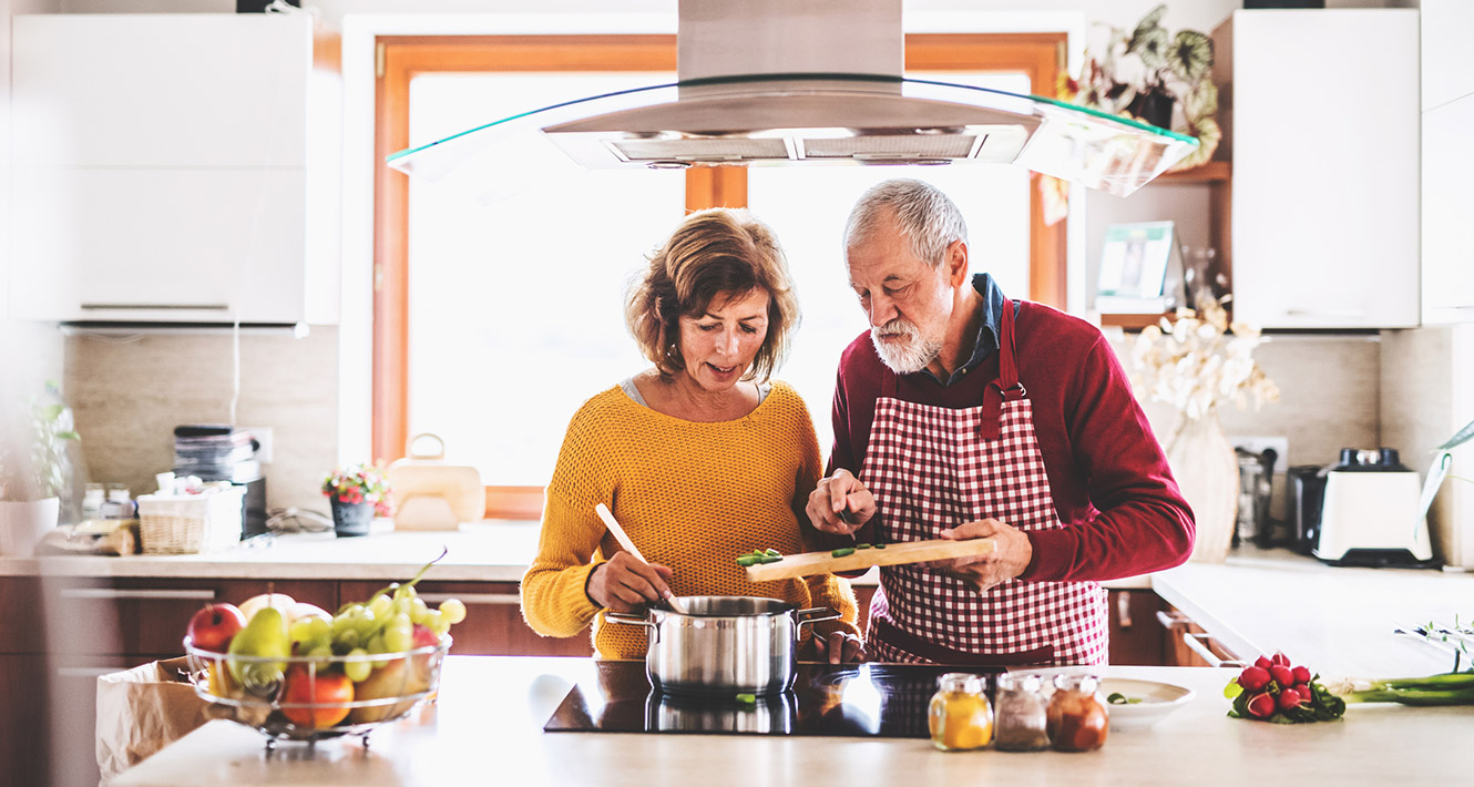 Mature couple cooking in kitchen