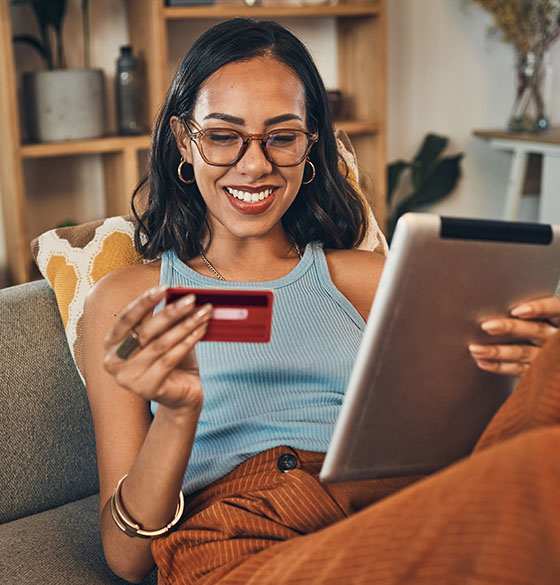 Happy checking account customer with tablet and debit card