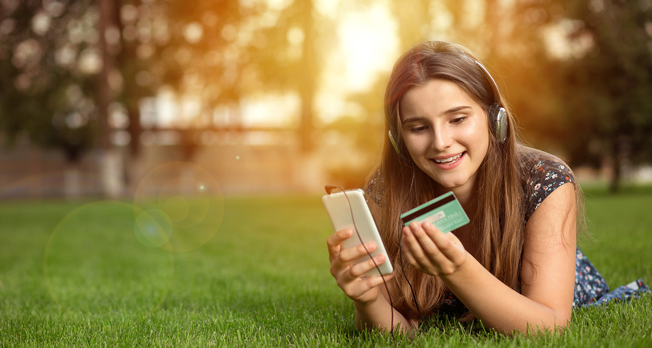 Teenager with debit card and phone