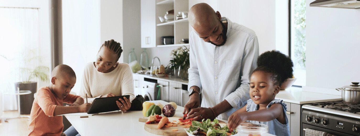 Family of four making dinner in their kitchen